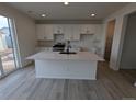 Modern kitchen with island, stainless steel appliances, and white cabinets at 8102 Butte Creek St, Littleton, CO 80125