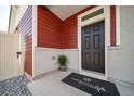Modern front entrance with dark door and red siding at , Aurora, CO 80019