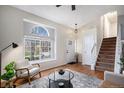 Bright living room featuring hardwood floors, a cozy armchair, and large window at 4028 Ashcroft Ave, Castle Rock, CO 80104