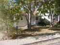 Cute bungalow with a white picket fence and mature trees in the front yard at 765 S Krameria St, Denver, CO 80224