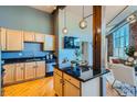 Modern kitchen with light wood cabinets, granite counters, and stainless steel appliances at 2441 N Broadway # 108, Denver, CO 80205