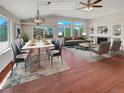 Virtually staged living room with hardwood floors, a fireplace, and large windows at 5879 S Versailles St, Aurora, CO 80015