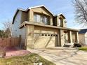 Two-story house with tan exterior, a three-car garage, and a well-maintained lawn at 12578 Dexter Way, Thornton, CO 80241