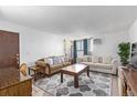 Living room with sofa, coffee table, and large TV at 381 S Ames St # B103, Lakewood, CO 80226