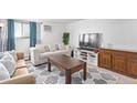 Living room with sofa, coffee table, and large TV at 381 S Ames St # B103, Lakewood, CO 80226
