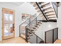 Modern floating staircase with wood treads and black metal railings in a bright foyer at 2381 S Franklin St, Denver, CO 80210