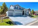 Two-story house with gray siding, three-car garage, and a landscaped front yard at 2053 S Cathay Way, Aurora, CO 80013