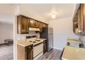 Galley kitchen with wood cabinets, updated flooring, and appliances at 7395 E Eastman Ave # 210L, Denver, CO 80231