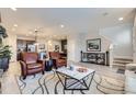 Open-concept living space with hardwood floors, comfortable seating, and views into the kitchen at 6621 N Ceylon St, Denver, CO 80249