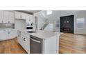 Modern kitchen with white cabinets, island, and fireplace at 3452 N Gold Bug Ct, Aurora, CO 80019