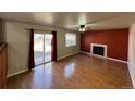 Living room with hardwood floors, fireplace, and sliding glass doors to patio at 19093 E Bellewood Dr, Aurora, CO 80015