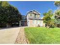 Inviting two-story home with a paved driveway, landscaped yard, and rocking chairs on the porch at 1612 E 164Th Pl, Thornton, CO 80602