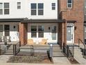 Townhome's front porch with modern seating and a black metal fence at 3053 W Bates Ave, Denver, CO 80236