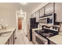 Galley kitchen with stainless steel appliances and light grey cabinets at 8853 Colorado Blvd # A-106, Thornton, CO 80229