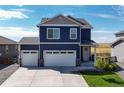 Two-story blue house with white two-car garage and landscaping at 45780 Silverdrop Ave, Bennett, CO 80102