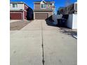 Long driveway leading to a two-car garage with a spacious backyard at 5046 Espana Way, Denver, CO 80249
