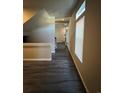 Long hallway with dark hardwood floors and access to upper level at 5046 Espana Way, Denver, CO 80249