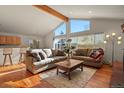Spacious living room with vaulted ceilings, hardwood floors, and a wood beam at 28730 Mountain View Rd, Conifer, CO 80433