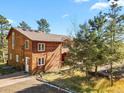 Two-story home with wood siding and a gravel driveway at 28730 Mountain View Rd, Conifer, CO 80433