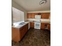 Galley kitchen with wood cabinets and tiled floor at 4361 Argonne St, Denver, CO 80249
