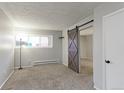 Bright bedroom with carpeted floor and barn door at 12171 Melody Dr # 102, Denver, CO 80234