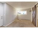 Bright bedroom with carpeted floor and barn door at 12171 Melody Dr # 102, Denver, CO 80234