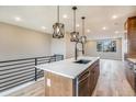 Modern kitchen with island, stainless steel appliances, and light wood cabinets at 2048 S Holly St # 2, Denver, CO 80222