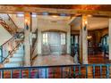 Elegant entryway with a wooden staircase and view into the dining room at 5764 Amber Ridge Dr, Castle Pines, CO 80108
