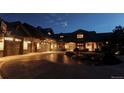 Exterior view of home at night, showcasing architectural details and landscaping at 5764 Amber Ridge Dr, Castle Pines, CO 80108