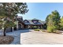 Stunning two-story home with a circular driveway and landscaping at 5764 Amber Ridge Dr, Castle Pines, CO 80108
