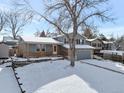 Two-story house with gray siding, attached garage, and snowy front yard at 13722 W 67Th Pl, Arvada, CO 80004