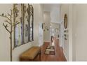 Bright entryway with hardwood floors, decorative mirrors, and a bench at 17027 Pale Anemone St, Parker, CO 80134