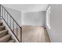 Living room with grey walls, light wood-look flooring, and staircase at 1553 S Pierson Ct, Denver, CO 80232