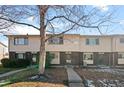 Three-unit townhouse building exterior with a tree in the front and walkway at 1290 S Troy St, Aurora, CO 80012