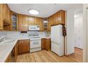 Bright kitchen with wood cabinets, white appliances, and light countertops at 660 S Alton Way # 5C, Denver, CO 80247