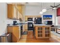 Modern kitchen with wood cabinets and island at 1555 California St # 316, Denver, CO 80202