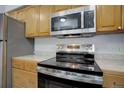 Stainless steel range and microwave in a wood cabinet kitchen at 14602 E 2Nd Ave # 100C, Aurora, CO 80011
