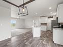 Open kitchen with white cabinets, island, and stainless steel appliances at 165 S County Road 197, Byers, CO 80103