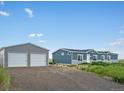 House and detached garage with a long driveway at 165 S County Road 197, Byers, CO 80103