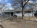 Ranch-style home with a chain link fence at 1599 W Beekman Pl Pl, Denver, CO 80221