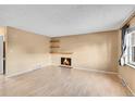 Living room with fireplace, hardwood floors, and window at 5667 S Lowell Blvd, Littleton, CO 80123