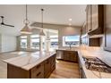 Modern kitchen featuring an island, stainless steel appliances, and hardwood floors at 37057 Still Rock Pt, Elizabeth, CO 80107