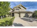 Two-story house with stone accents, two-car garage, and landscaped lawn at 7892 S Country Club Pkwy, Aurora, CO 80016