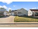 Cute ranch home with a brick walkway and a neatly landscaped yard at 4945 Elm Ct, Denver, CO 80221