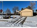Front view of a ranch home with a snow-covered driveway at 15503 E Princeton Ave, Aurora, CO 80013