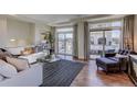 Spacious living room with hardwood floors, large windows, and access to a balcony at 1230 Sugarloaf Ln, Erie, CO 80516
