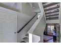 Modern staircase with gray carpeting and wooden handrail at 1230 Sugarloaf Ln, Erie, CO 80516