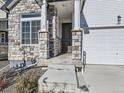 Inviting front entry with stone accents and covered porch at 16487 E 111Th Pl, Commerce City, CO 80022