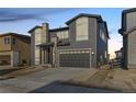 Two-story home with gray siding, stone accents, and a two-car garage at 6666 Bridle Creek Pt, Castle Pines, CO 80108