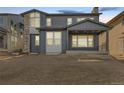 Rear view of a two-story home with gray siding and a covered patio at 6666 Bridle Creek Pt, Castle Pines, CO 80108